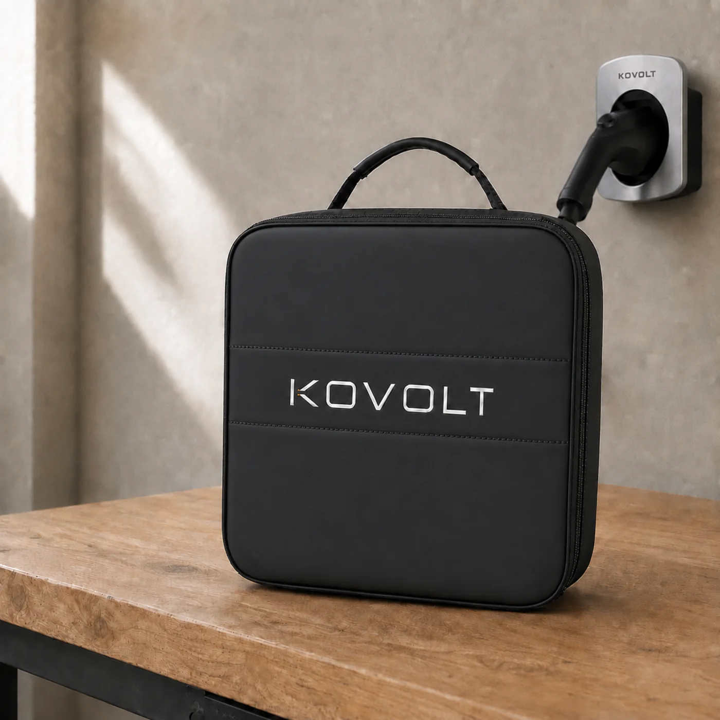 The Kovolt Case on a workbench beside a wall-mounted Type 2 connector holder.